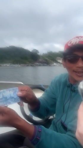 Motorboat passengers travel to lakeside temple complex in Baturiti