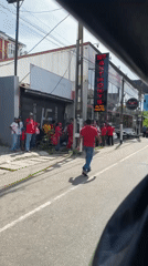 Red-clad crowd gathers on Delkanda street, Sri Lanka