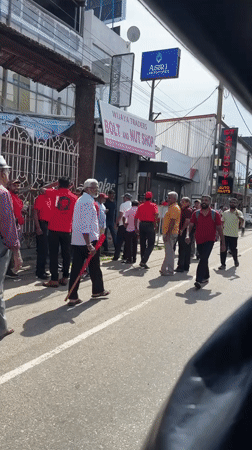 Red-clad crowd gathers on Delkanda street, Sri Lanka