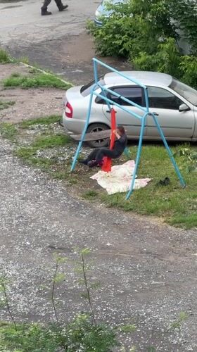 Aerial yoga in a hammock on an outdoor swing set, Izhevsk