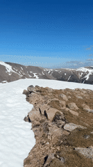 Snow-covered mountain landscape observed under sunny skies