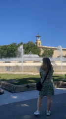 Tourists explore Barcelona's Montjuïc landmarks on sunny afternoon