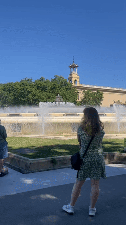 Tourists explore Barcelona's Montjuïc landmarks on sunny afternoon