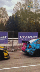 Race cars line up at track with marshal present