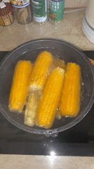 Fresh corn boiling on a stovetop in Islamabad