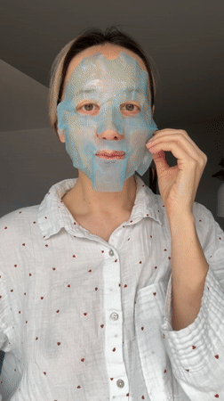 Woman applies facial mask during morning skincare routine in Latvia
