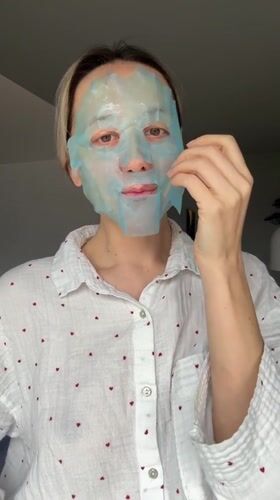 Woman applies facial mask during morning skincare routine in Latvia