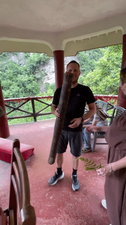 Tourists ring ceremonial bell at Wulingyuan scenic overlook pavilion