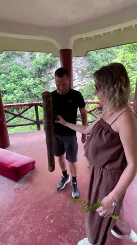 Tourists ring ceremonial bell at Wulingyuan scenic overlook pavilion