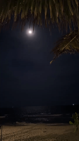 Full moon illuminates tranquil beach scene in Thailand