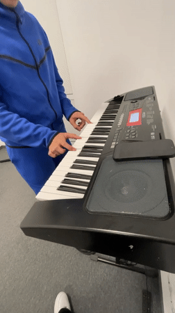 Musician practices keyboard in blue tracksuit, Zlatograd Bulgaria