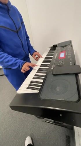 Musician practices keyboard in blue tracksuit, Zlatograd Bulgaria