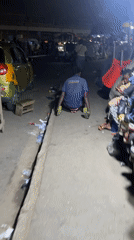 Man navigates nighttime street market in Accra, Ghana