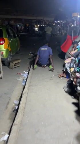 Man navigates nighttime street market in Accra, Ghana
