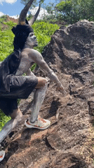 Horned performer in body paint climbs rock in Nigeria