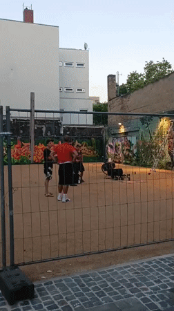 Makeshift volleyball game in a fenced outdoor space, Rüsselsheim
