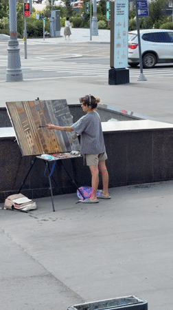 Artist paints urban landscape on a Moscow sidewalk