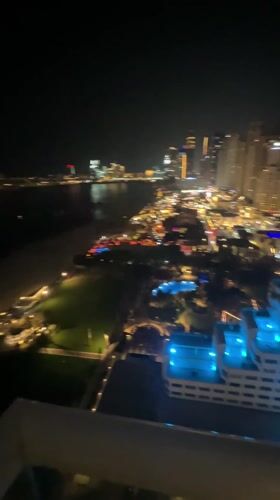 Nighttime panoramic view captures Dubai's illuminated waterfront skyline