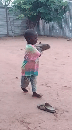 Kids play and wood gets chopped in a Nigerian yard