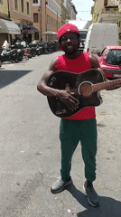 Street musician performs with guitar in Livorno, Italy