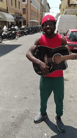 Street musician performs with guitar in Livorno, Italy