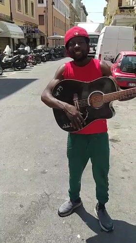 Street musician performs with guitar in Livorno, Italy