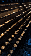 Woman lights prayer candle in Vienna cathedral
