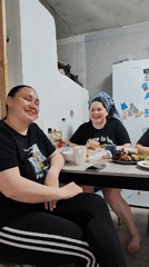 Family gathering documented in Пушкари home during afternoon meal