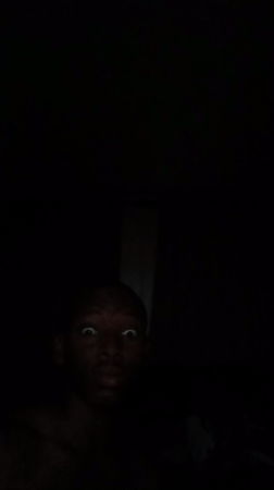 Person photographed in darkness with illuminated face in Lagos
