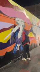 Night mural painting in progress on Arica street wall