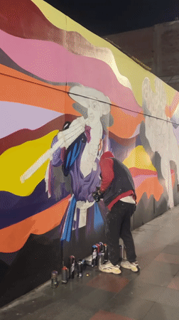 Night mural painting in progress on Arica street wall