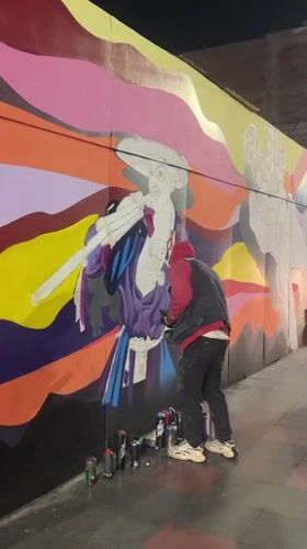 Night mural painting in progress on Arica street wall