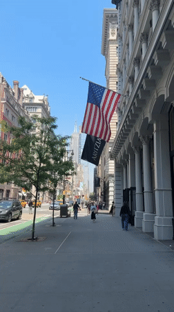 NYC street scene captures Empire State Building view with flags