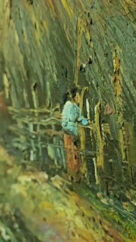 The video is a close-up, panning shot of a painting depicting a rural village scene. The painting is rendered in oil with thick impasto brushstrokes, giving it a textured appearance. In the foreground, the painting shows a muddy path leading towards a cluster of thatched-roof huts. A rickety wooden fence encloses a small area in front of one of the huts. A person, wearing a blue top and red/brown skirt or pants, is standing near the fence, appearing to be engaged in some activity. Several large ceramic pots are visible near the huts. In the background, lush green foliage and trees suggest a natural, possibly tropical environment. The painting captures a sense of rustic simplicity and everyday life in a village setting.