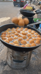 Street vendor fries dough balls in Bukuru, Nigeria