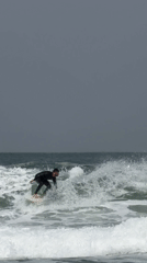 Surfer rides wave in overcast conditions off Tel Aviv
