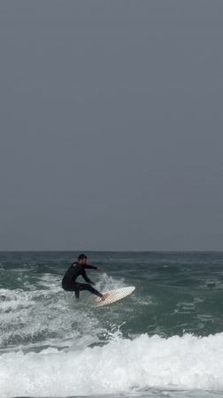 Surfer rides wave in overcast conditions off Tel Aviv