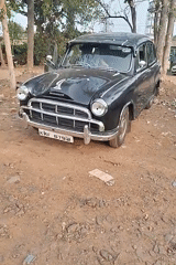 Man sits in parked Ambassador car in Kalamassery