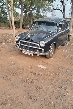 Man sits in parked Ambassador car in Kalamassery