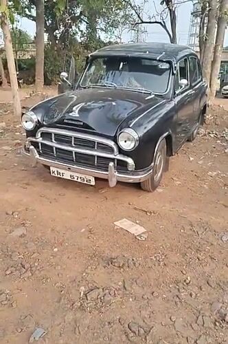 Man sits in parked Ambassador car in Kalamassery