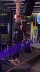 Woman performs live music at evening restaurant venue