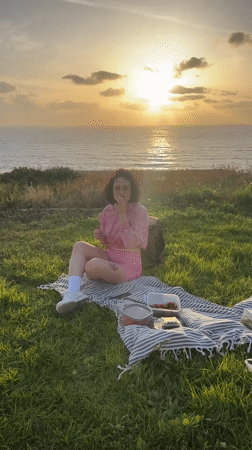 Woman enjoys seaside picnic with strawberries in Netanya