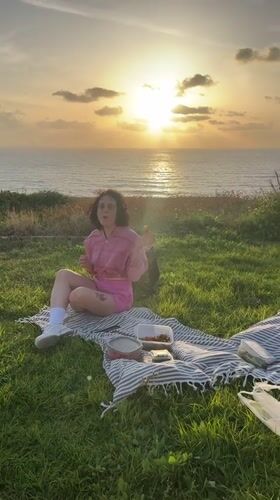 Woman enjoys seaside picnic with strawberries in Netanya