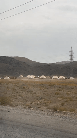 Canvas tents lined up across a barren rocky landscape in Pakistan