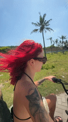 Tourists ride scooters along Indonesian coastal roads near resort area