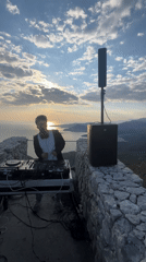 DJ performs sunset set on stone overlook in Montenegro