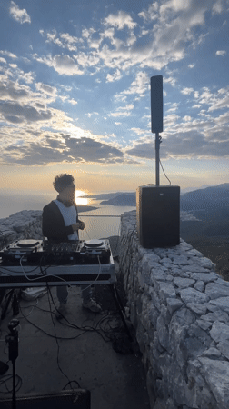 DJ performs sunset set on stone overlook in Montenegro