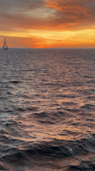Dramatic sunrise captured over Gulf of Mexico industrial seascape
