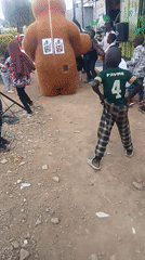 Bear mascot entertains children at community gathering in Kenya