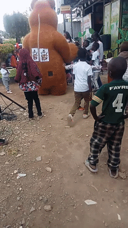 Bear mascot entertains children at community gathering in Kenya